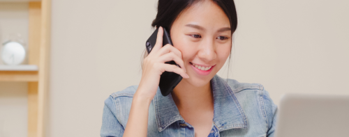 figura feminina em chamada no telefone ao olhar o notebook